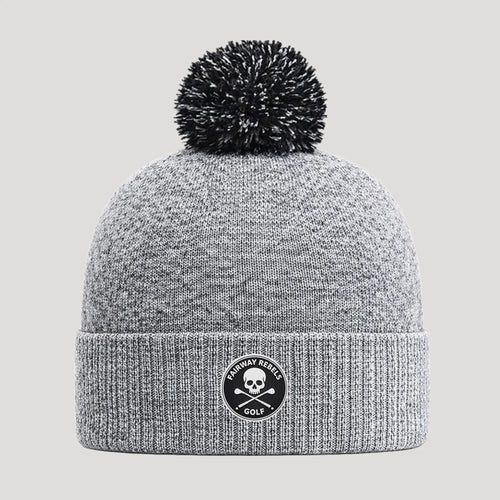 Bonnet de golf gris avec pompon noir et logo tête de mort, style technique hiver.
