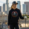 Femme golfeuse en hoodie noir à capuche, logo tête de mort, tenue urbaine, gant et club de golf