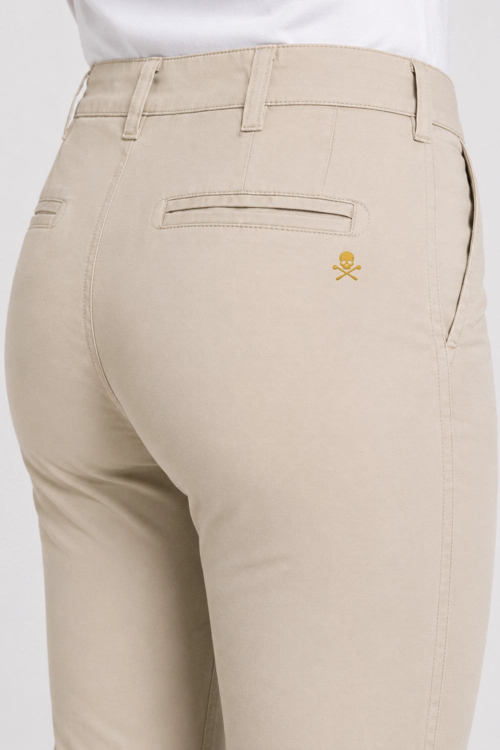 Pantalon chino de golf beige clair, gros plan sur la poche arrière avec petit logo brodé.