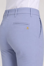 Pantalon de golf chino bleu clair, poche arrière et emblème discret.