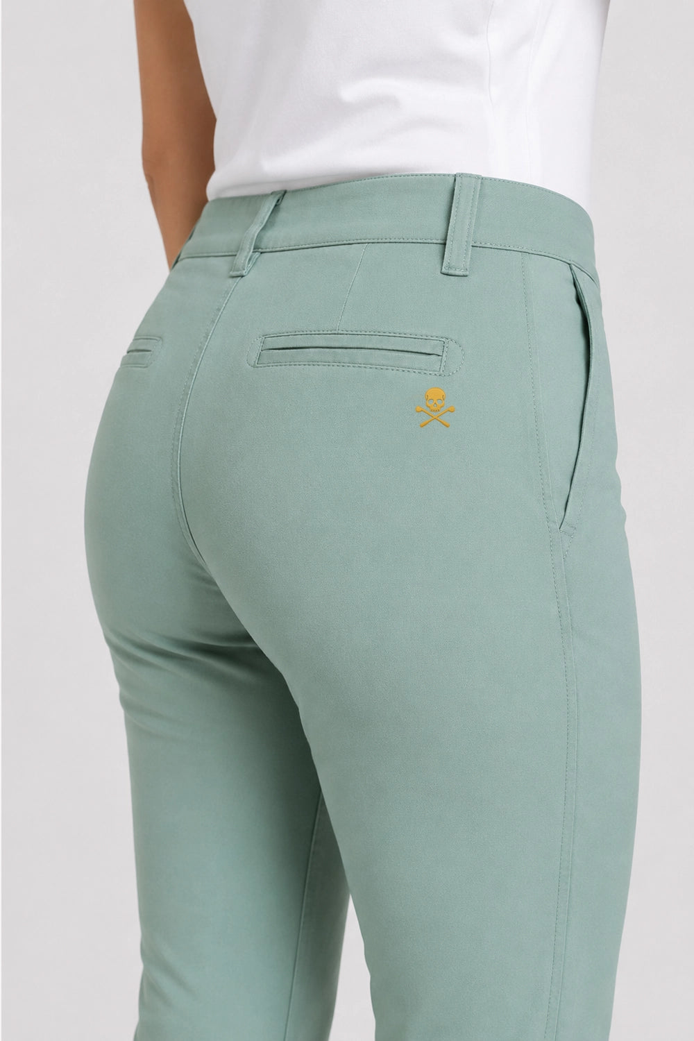 Pantalon chino femme vert sauge, vue arrière avec logo brodé discret et poches.