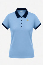 Polo de golf femme bleu ciel, col marine à boutons, logo poitrine discret.