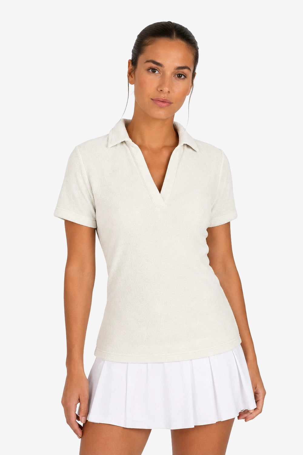 Polo femme beige clair en tissu éponge, col V et patte boutonnée, manches courtes.