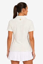 Polo femme beige clair, dos avec petit logo croix et tête sur le col, manches courtes.