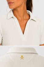 Polo femme beige clair, col V et logo sur le dos du col.