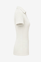 Polo femme beige clair coupe ajustée, vue de côté, manches courtes.