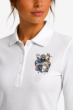 Polo manches longues femme blanc, col à trois boutons et blason brodé sur le cœur.