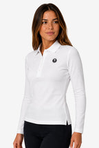 Polo manches longues femme en coton blanc, col polo et écusson sur la poitrine.