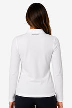 Polo manches longues femme en coton blanc, vue dos, écusson discret près du cou.