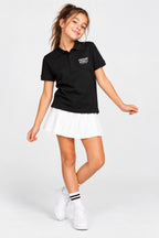 Polo fille noir en coton, col boutonné, logo sur la poitrine, avec jupe blanche plissée