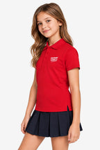 Polo technique golf fille rouge, col boutonné, logo poitrine, porté.
