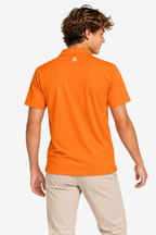 Polo de golf technique orange garçon, dos uni avec petit logo au centre.