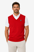 Pull de golf sans manches rouge à col V, écusson poitrine, porté sur polo blanc