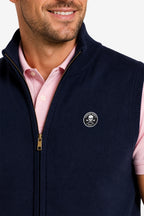 Gilet golf zippé sans manches bleu marine, gros plan zip doré et logo poitrine.