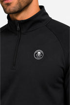 Détail pull homme noir : demi-zip au col montant et écusson logo sur la poitrine.