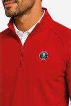 Pull de golf homme rouge, détail demi-zip et badge rond sur la poitrine