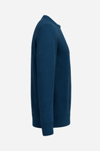 Sweat de golf femme bleu marine, vue de côté, manches longues et ourlets côtelés.