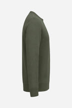 Sweat de golf femme vert foncé, vue de côté, manches longues et ourlet côtelé.