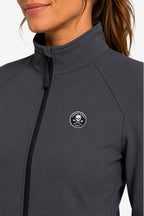 Veste de golf déperlante gris, col montant et badge rond sur la poitrine.