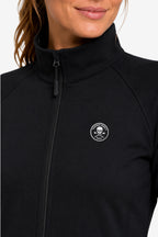 Veste de golf déperlante noire femme, gros plan col montant et fermeture zippée, logo rond.
