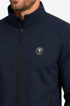 Veste de golf déperlante bleu marine, logo rond sur la poitrine, zip visible.