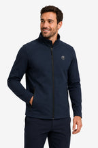 Veste de golf déperlante bleu marine, zip noir, col montant et logo poitrine.