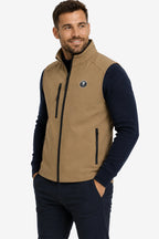 Veste golf sans manches déperlante beige, vue de trois quarts avec poches zippées.