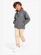 Veste de pluie enfant grise zippée, tenue avec pantalon beige et baskets blanches